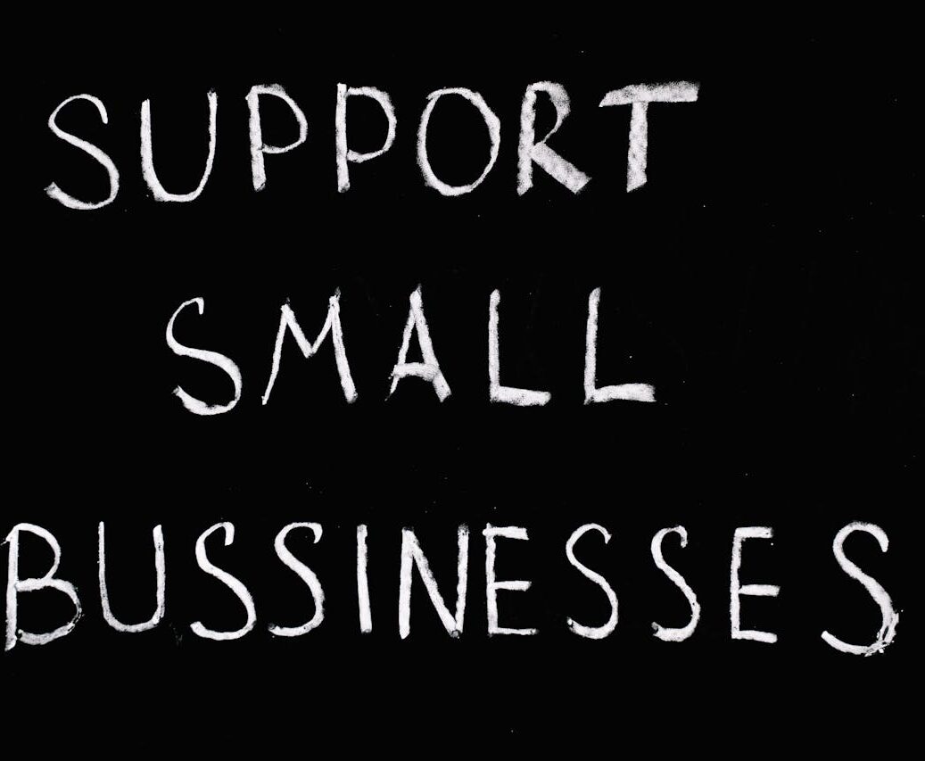 Inspirational chalkboard text 'Support Small Businesses' on black background.